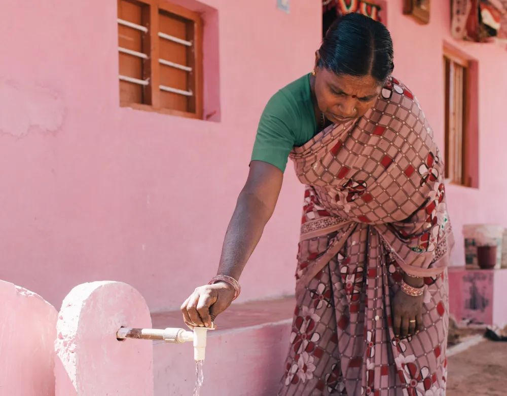 Femme ouvrant un robinet d'eau Femme en sari utilisant un robinet